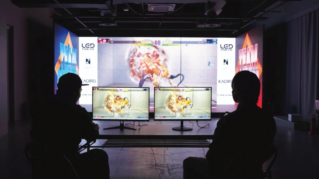 YOKOHAMA STUDIOのLEDビジョンにゲーム映像を放映しながらストリートファイター6をプレイしている画像